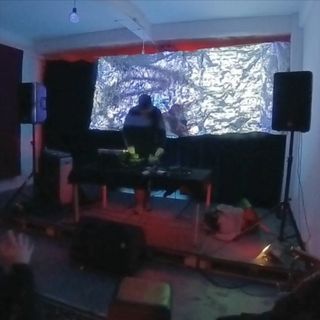 Man playing live concert with silver foil in the background